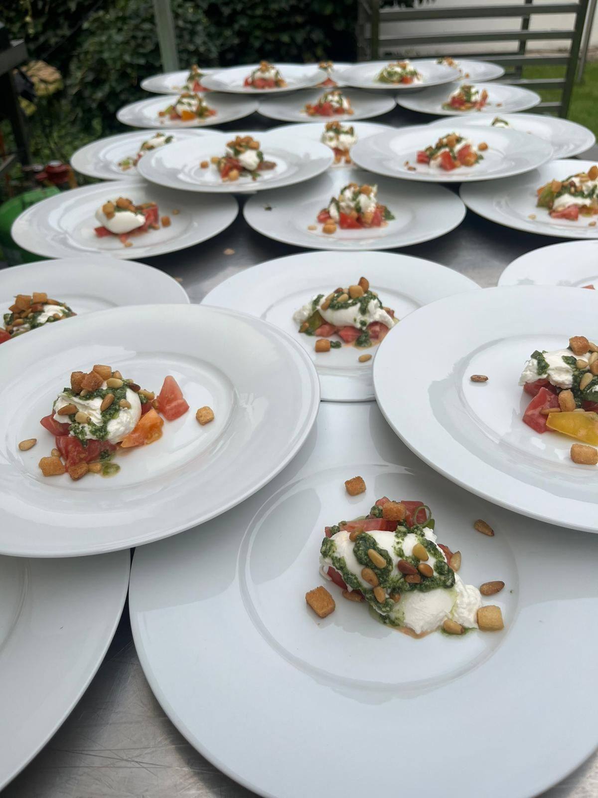 Burrata mit Tomaten, Pesto und Pinienkernen, angerichtet für eine Veranstaltung