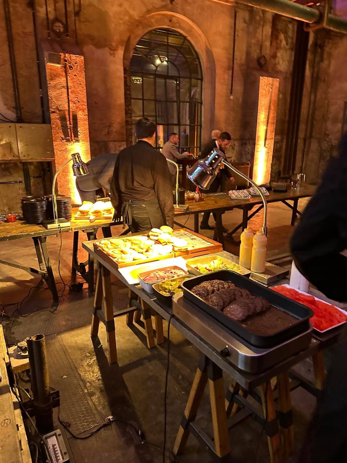 Live-Cooking-Station mit Burgern in einer historischen Industriehalle